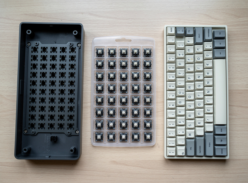 Under-100-dollar keyboard build laid out: hotswap board, a 90-pack of switches, and a PBT keycap set with the budget split noted