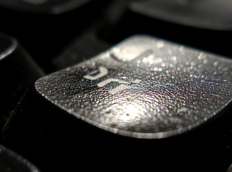 The shiny worn surface of a doubleshot ABS spacebar after a year of daily use