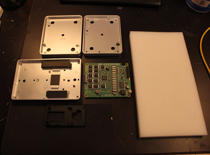 Disassembled mechanical keyboard showing case, plate, PCB and foam layers laid out