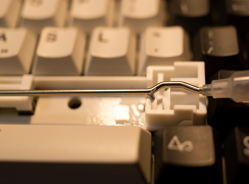 Greasing the long spacebar stabilizer wire at one bent end