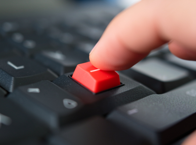 Finger pressing a single red linear mechanical keyboard switch on a board