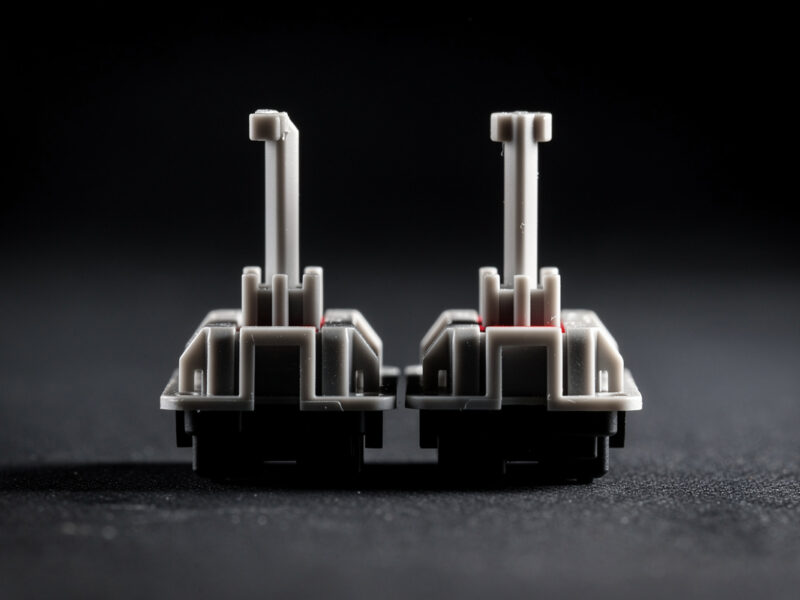 Two keyboard switch stems compared, one with a longer center pole than the other
