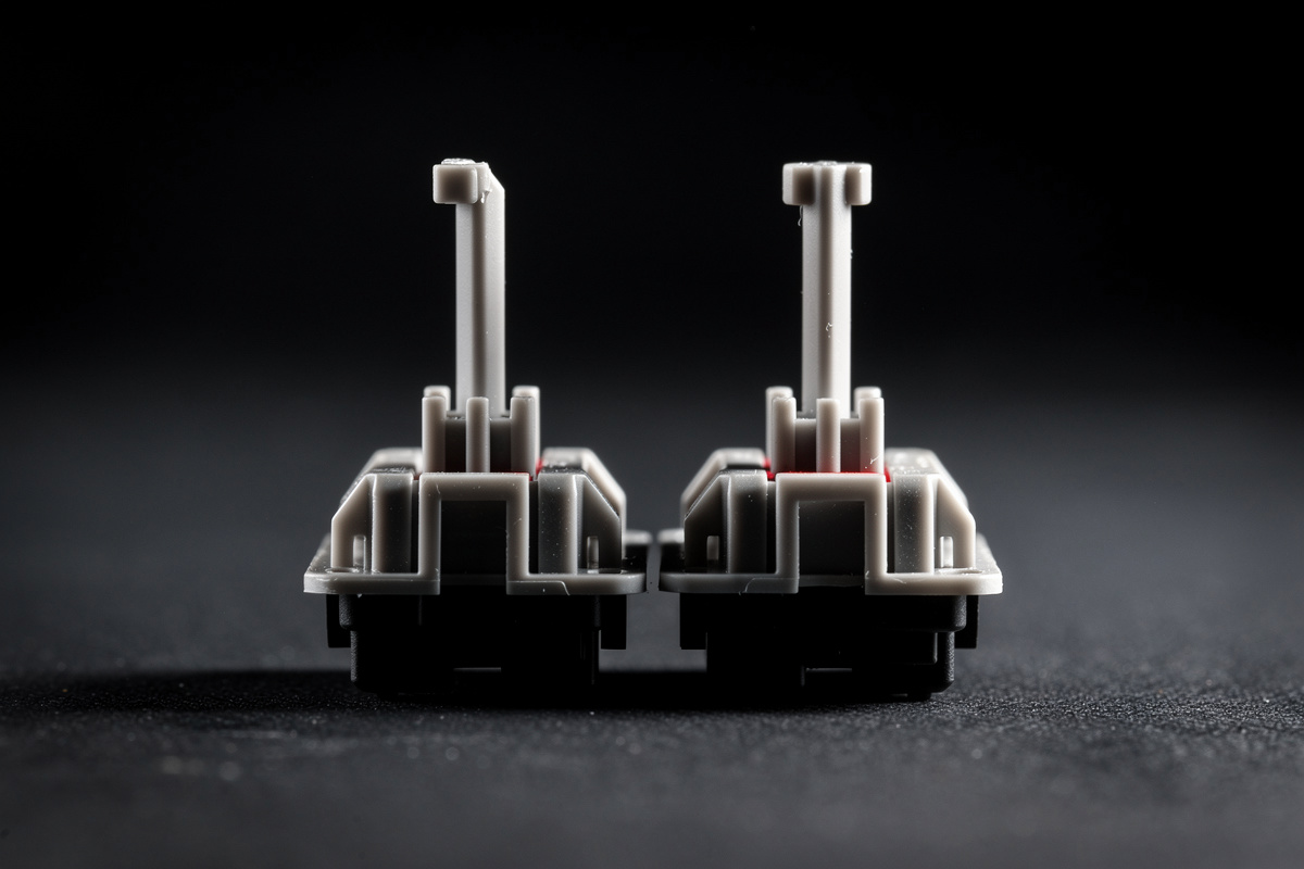 Two keyboard switch stems compared, one with a longer center pole than the other