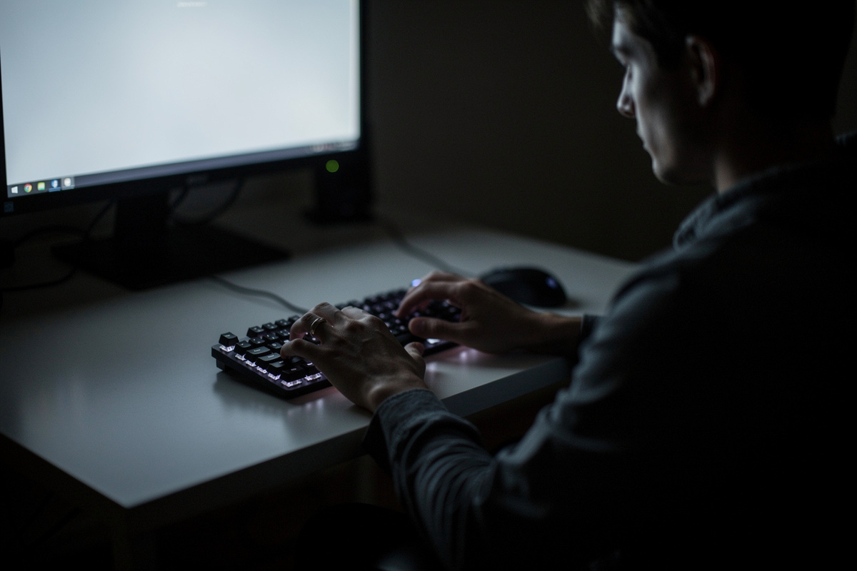 Person typing quietly on a mechanical keyboard in a dim room at night