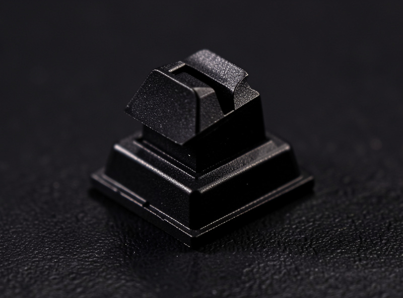 Keyboard switch with a keycap half removed showing the LED slot at the top edge of the housing