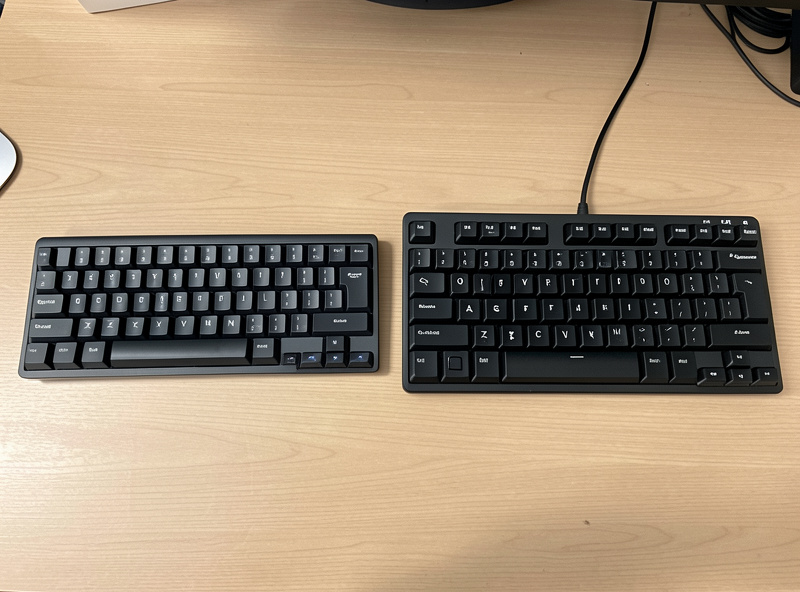 A compact 60 percent gaming keyboard and a full-size office keyboard side by side showing layout differences
