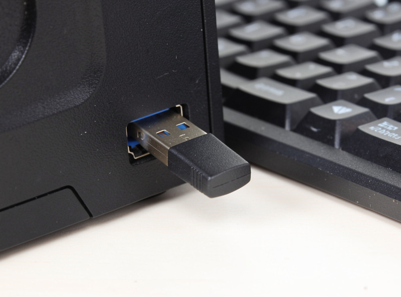 A 2.4GHz USB dongle plugged into a front USB port near a wireless gaming keyboard